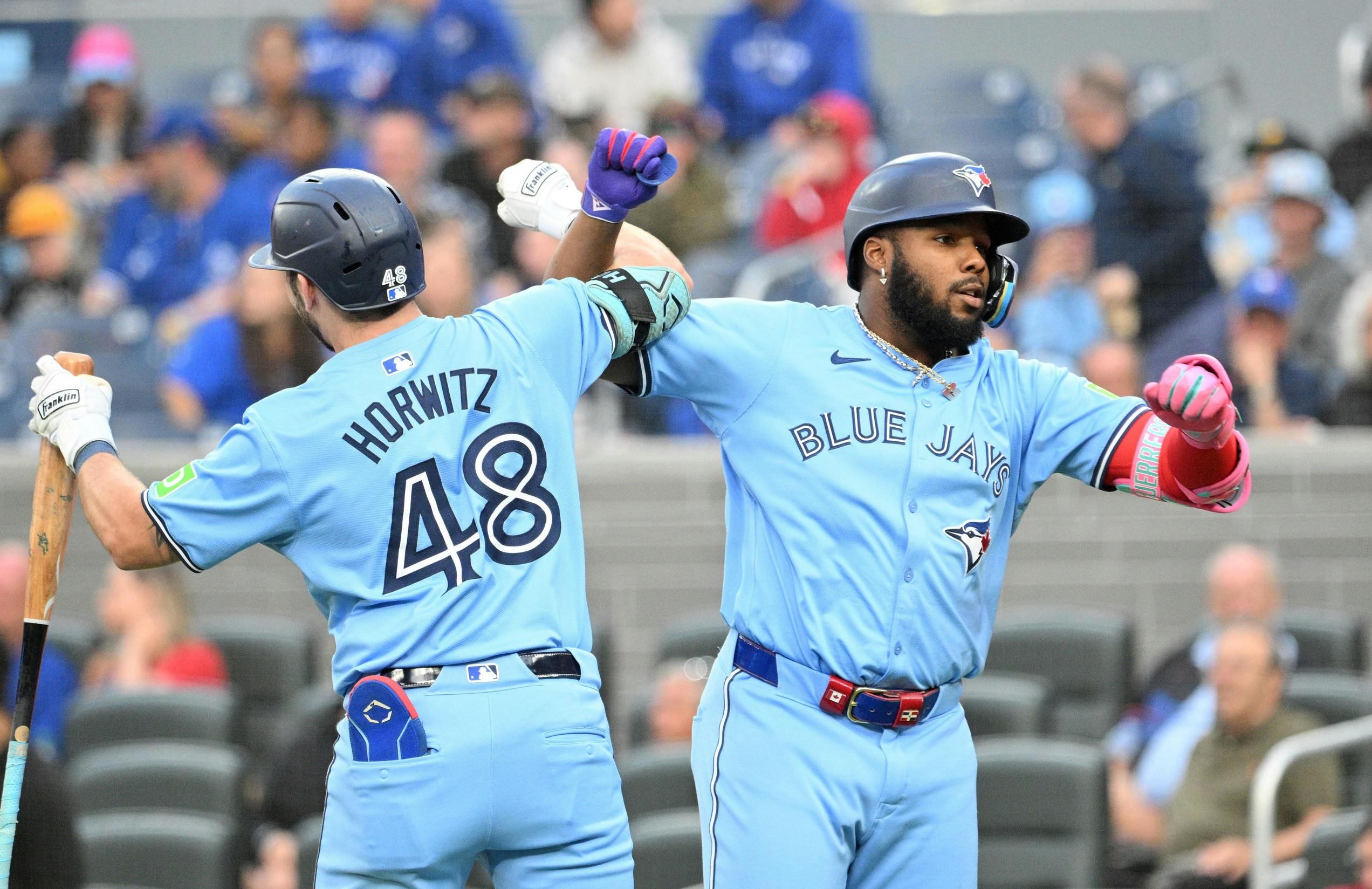 Toronto Blue Jays designated hitter Vladimir Guerrero Jr. (27) celebrates with first baseman Spencer Horwitz (48) after hitting a solo home run against the Cincinnati Reds in the first inning at Rogers Centre.