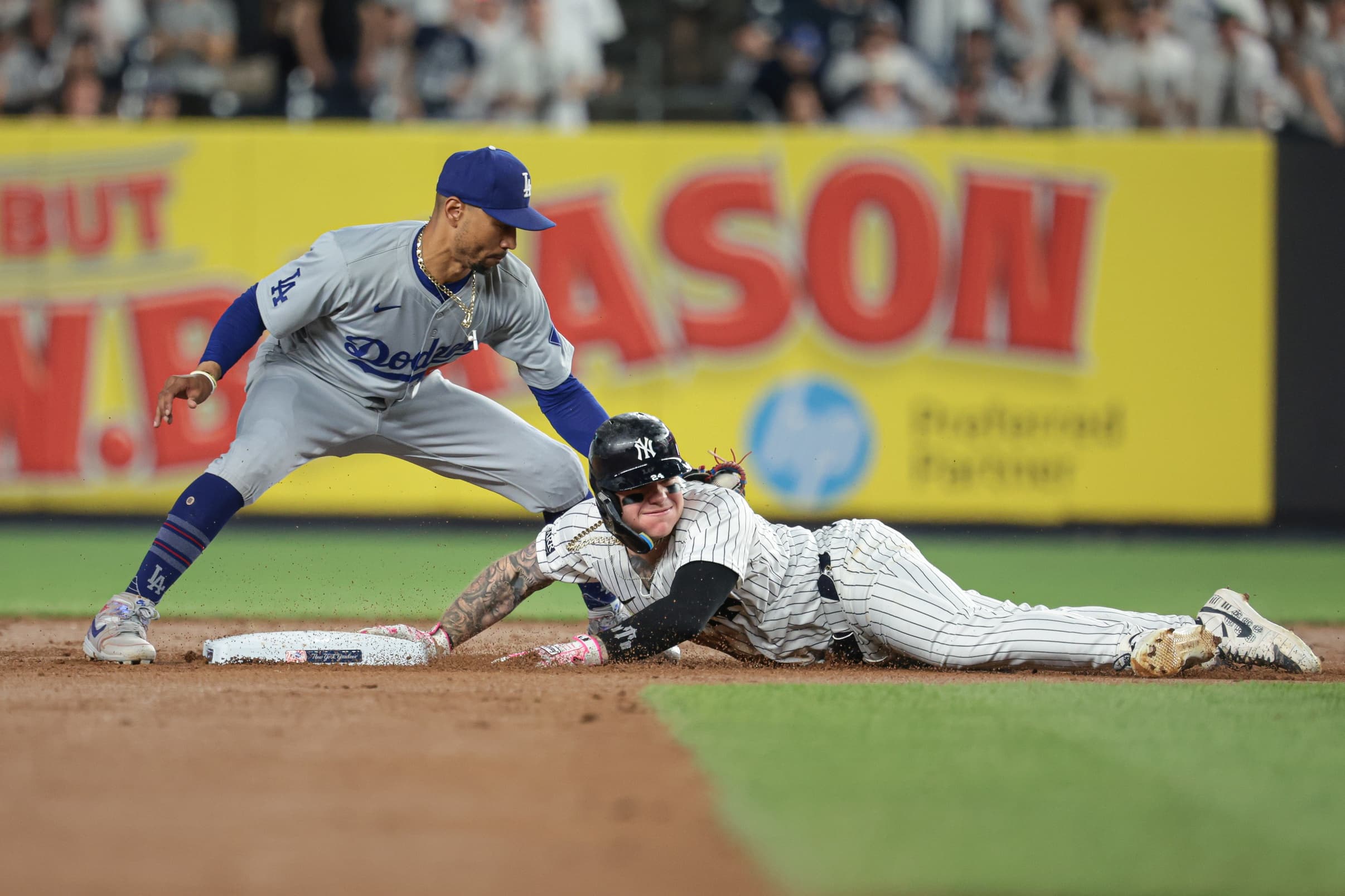 New York Yankees left fielder Alex Verdugo (24) dives safely in to second base beating the tag by Los Angeles Dodgers shortstop Mookie Betts (50) during the fifth inning at Yankee Stadium.